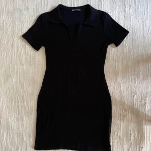 Svart klänning från Zara - 🌟Storlek L, passar snarare S/M. 🌟T-shirtärm. 🌟V-ringning/piké. 🌟Kort kjol. 