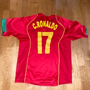 Cristiano Ronaldo Portugal 2004 hemma tröja 🇵🇹 - Säljer en gammal Portugal tröja från 2004 med C.Ronaldo #17 på ryggen 🐐🇵🇹, tröjan är i lite slitet skick då den är så gammal (Pris kan diskuteras)