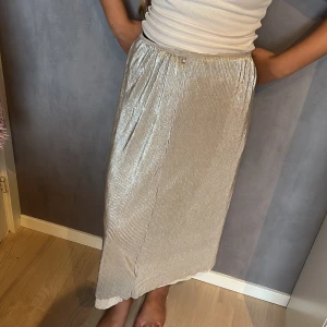 Kjol -  Silver glittrig kjol i storlek M-L. Har två pytte små hål i Resårbandet men syns inte. Kjolen har inte använts bara testats. 