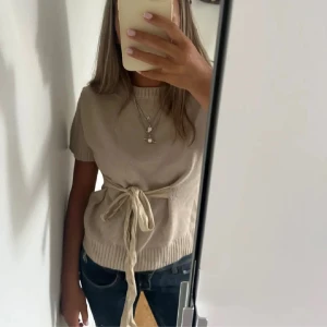 Stickad t-shirt med knytning  - Säljer min stickade t-shirt ifrån zara med knytning. Storlek xl men passar mig som har S. Bilden är lånad ifrån min kompis men sitter ungefär likadan.💕💕💕Nyköpt utan användning.