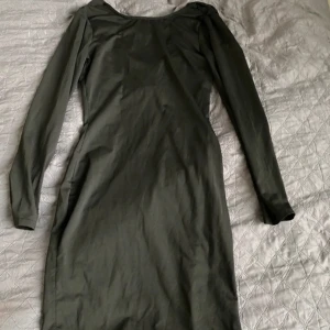 Svart långärmad klänning - En elegant svart långärmad klänning med en åtsittande passform. Klänningen har en enkel design utan mönster och är tillverkad i ett mjukt och stretchigt material. i ryggen är klänningen öppen så att det hänger som en U-ringning💕