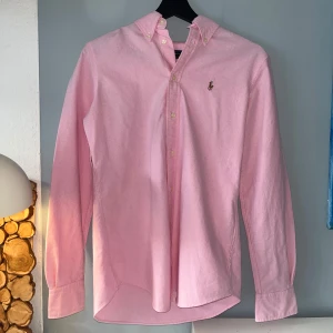 Ralph Lauren - Säljer en fet Ralph Lauren skjorta i färgen rosé. Skjortan är omsydd så den sitter som XS. Man tänker inte på sömmarna men om man kolllar noga på ryggen kan man se de. Tveka inte på att höra av dig !
