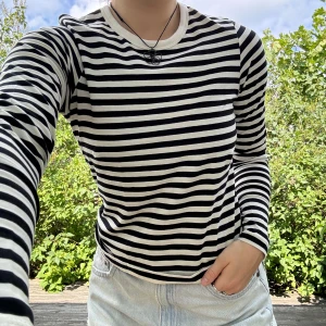 Randig, stretchig tröja - Svart/vit randig, stretchig tröja med långa armar från JJXX. Storlek: M(lite mindre i storleken). Material: 95% bomull + 5% elastan. Nyskick! Använd cirka tre gånger! :)