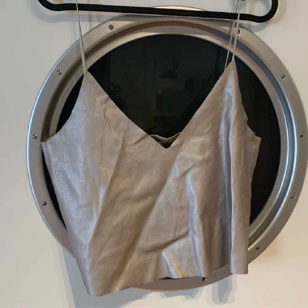 Metallisk faux leather topp i silver/champagne färg. Aldrig använt. Strl L.. Toppar.