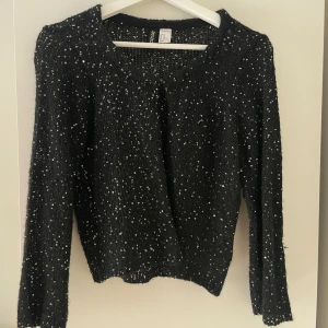 Paljett kofta  - Stickad svart kofta med färg glada paljetter! Passar till allt och så fin till fest