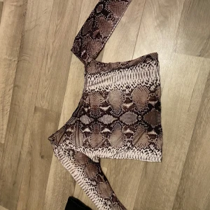 Topp från BooHoo - Ormskinn färgad topp från BooHoo, klippt längst nere men inget man märker av. One shoulder.