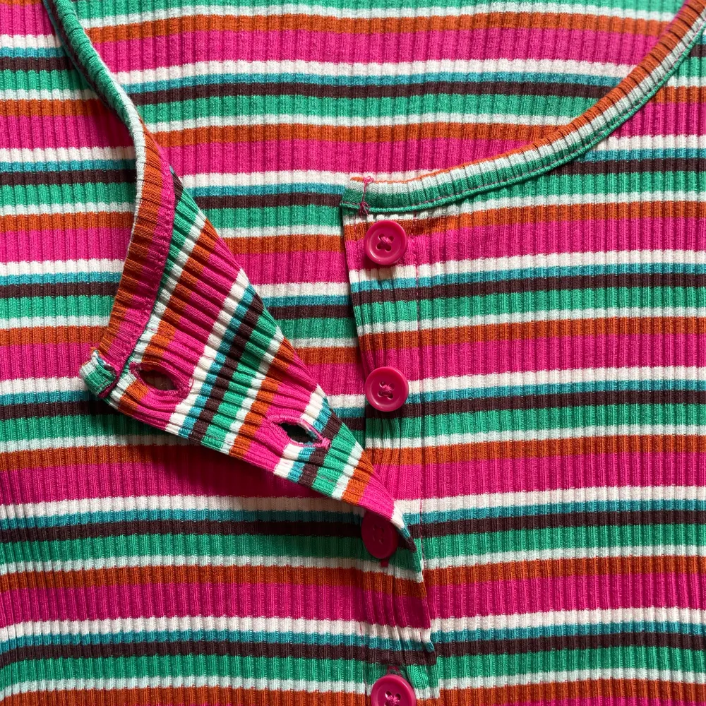 Jättefin elastisk långärmad tröja med knappar hela vägen fram. Vid krage som är väldigt smickrande och så fint med halsband! Vackra vårfärger som gör alla glada!. Tröjor & Koftor.
