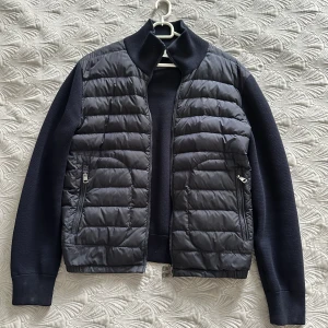 Moncler Cardigan - Säljer nu min Moncler cardigan (M) i ”Navy Blue” pga att den inte passar längre. Köptes i september 2023 från ”garmsmarket.com” och är väldigt sparsamt använd, Skick 9/10. Såklart äkta, e-kvitto från köpet i september finns. 