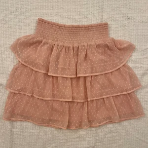 Rosa kjol - Rosa volangkjol från Lindex. Storlek 158/164 (barn) men passar mig som normalt sett bär storlek XS. Använd men i fint skick. 