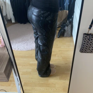 Mönstrade byxor  - Intressekoll på mina fina ormmönstrade byxor. Materialet är lite skinn aktigt men ändå inte. Nyskick. Står ingen storlek men passar mig som har vanligtvis 38-40 på byxor/jeans. Frakten står köparen för❤️