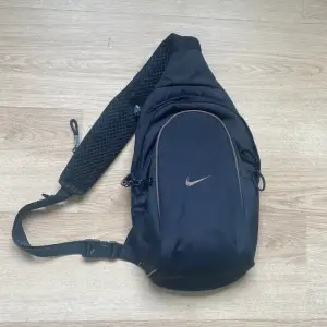 Svart Nike Sling Bag som rymmer 8 liter tror jag. Inga vidare tecken på användning förutom kanske nåt litet litet slitage nånstans. DMa för frågor. 