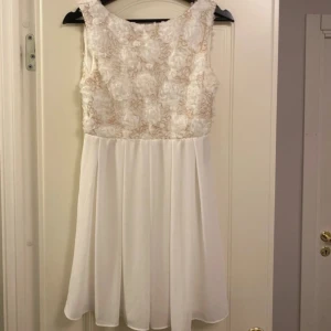 Studentklänning  - Vit kort klänning perfekt till student eller skolavslutning. Använd en gång på ett dop så i väldigt fint skick. Storlek 38 men passar mig som brukar ha S