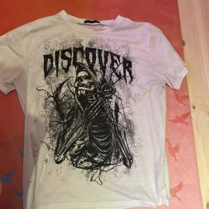 En grunge t-shirt med texten ”discover” på, den har blivit använd några få gånger så den ser nu ut!
