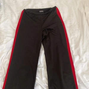 Byxor med vida ben - Stretchigt material och röda stripes på sidan.  Storlek S  Köpare står för frakt