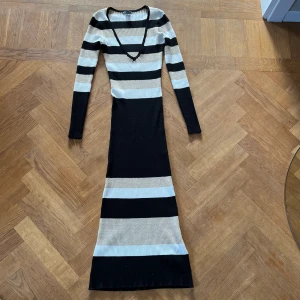 Finstickad klänning  - En jättefin finstickad klänning ifrån Lindex i vit, svart och guld. Klänningen är i nyskick.🩷