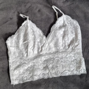 Vit spetslinne  - Jättesöt spetslinne perfekt till sommaren, dubbellager med tyg vid bröst, så ingen BH behövs. Ställbara axelband, ej spetstyg direkt mot kropp. Strl. M 