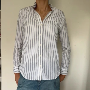 Gant skjorta - Den har blivit något missfärgad under armarna inifrån, se bilder, men ingenting som syns på utsidan. Även en liten fläck på ena armen men det är på baksidan vid knappen så inte heller något som syns. Ränderna är blå utanpå och bruna inuti
