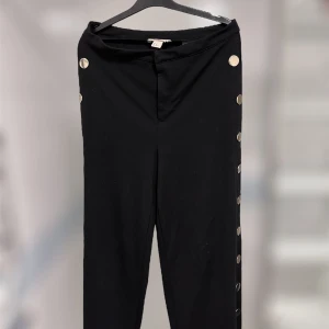 Byxor - Jättefina svarta byxor som är kortare i modellen! De är från hm och är i storlek 40. Den har knappar på båda sidorna där man kan knappa upp hur högt upp tills det tar stopp som man ser på sista bilden!! Använda en gång 