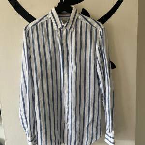 Blå/Vit randig Linneskjorta från Massimo Dutti, 100%linne Nästintill oanvänd och är nyskick.
