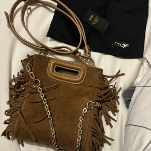 Maje väska  - Säljer min fina majeväska , i den lilla storleken 🩷 den är slutsåld och är i toppskick !! Man får med äktebevis, dustbag, axelband och kedjan 🫶🏻 skriv om ni har frågor 😘