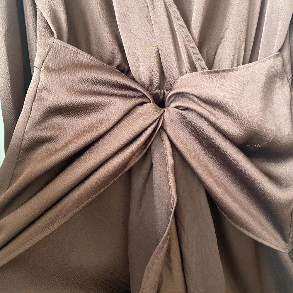 Brun klänning med detalj i mitten som man kan knyta och framhäva midjan. Använt en gång. Storlek Xs/S. Klänningar.