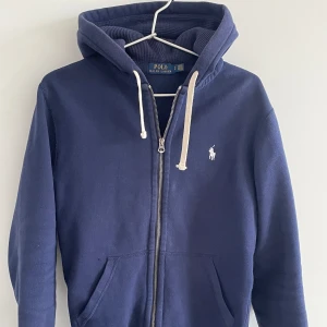 Polo Ralph Lauren Hoodie -  Riktigt snygg polo Ralph Lauren Hoodie i färgen blå💙 skicket är mycket bra, finns inga skador osv. Skriv vid intresse eller eventuella funderingar! TH.e Clothing 🗣️