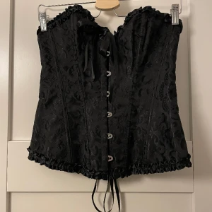 Svart korsett - Jättefin svart korsett med band där bak som man kan justera. Aldrig använd! Det står storlek L men den passar mer som XS/S