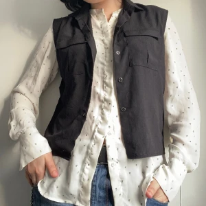 Svart H&M-väst - Sparsamt använd, i fint skick. Material polyester. Pris är diskuterbart. Hör gärna av er vid frågor! :)