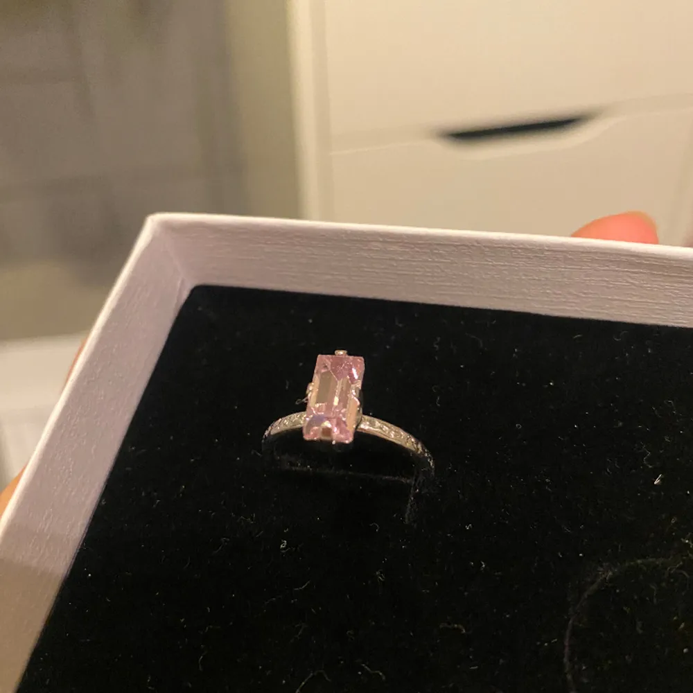 En silvrig ring med rosa sten från Caroline Svedbom! Fint skick!  Justerbar. Accessoarer.