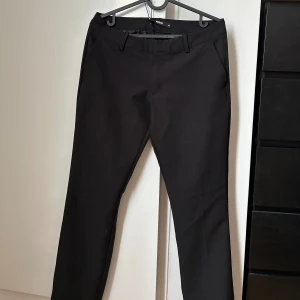 Kostymbyxa - Svarta utsvängda kostymbyxor från BikBok. Bra skick använda ca 5 ggr.