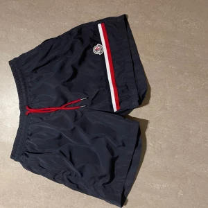 Moncler shorts - Hej! Säljer ett par moncler bad shorts som också som funkar som ett par vanliga shorts. Dom är oanvända o har inte skador alls 10/10, vid frågor om pris eller själva varan va inte rädd att slå iväg ett meddelande!