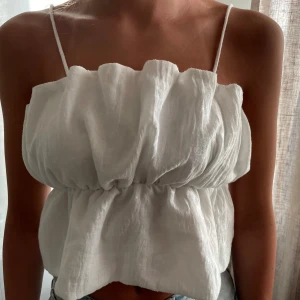 Vit zara topp - Kort volang top från zara, använd 1 gång, går att vika in banden och ha den som off shoulder