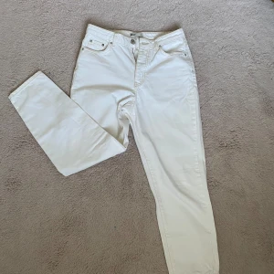 Vita jeans  - Vita jeans med bruna stygn detaljer från Gina Tricot som knappt är använda och därför i gott skick. Byxorna är högmidjade. 