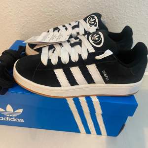 Adidas Originals Campus 00 s j 38 2/3 Svart (Core Black/Cloud White/Cloud White) Ingår både vita och svarta skosnören.  Nya och oanvända. Ligger kvar i kartong.  Köpta i svensk webbutik och kommer inte från någon massimport utomlands. Sista paret!