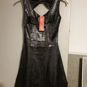 Svart glansig klänning - Aldrig använd Storlek 34-36