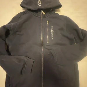 En mörk blå sail racing hoodie. - Storlek 160/S/XS. Mörkblå kofta/hoodie. Funkar bra båda till tjejer och killar. Bra skick! 