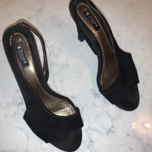 Klackskor Tiger of Sweden  - Stl 37, använda endast en kväll och därav inga defekter. Klacken är vid högsta punkten 9 cm. Svart sammetsliknande material på skon. 