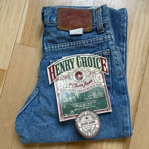 Vintage Jeans Henry Choice  - Vintage Jeans från Henry Choice, oanvända med lapp kvar då de legat på lager i massa år. Märkta storlek 146 men kolla mått, ungefär som storlek 32.   Mått är mätna rakt över platt.  Midja: 30 cm Höft/Stuss: 39,5 cm Beninnerlängd: 66,5 cm