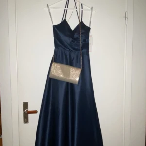 Marinblå balklänning (väska ingår ej) - Jag säljer min fina oanvända balklänning eftersom att jag inte är nöjd med färgen☺️ om du är intresserad skriv till mig. Den är helt oanvänd och prislappen sitter kvar❤️