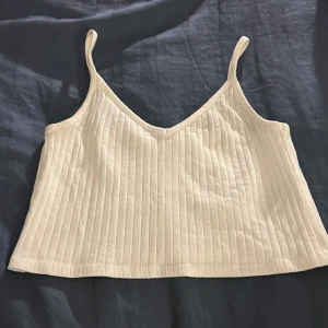 Vitt v-neck linne  - Vitt ribbat v neck linne ifrån Hm. inga defekter och perfekt till våren 