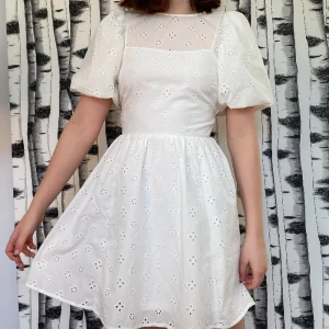 Sommarklänning  - Vit sommarklänning med gulliga broderade blommor på. Knytning i både nacke och rygg. Så himla söt och perfekt till sommar, midsommar och skolavslutning💕🌷