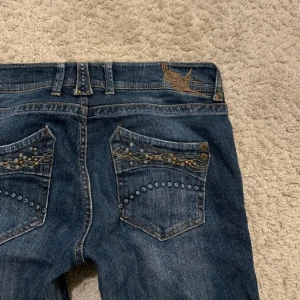y2k Bootcut Jeans  - Ett par sjukt snygga lågmidjade bootcut jeans med snygga detaljer bade fram och bak! Köpte dem pả Plick men har alldrig använts dả dem inte passade mig.  Midjemått tvärsöver: 41cm  Ineebenslängd:76cm Benbrädd:22cm 