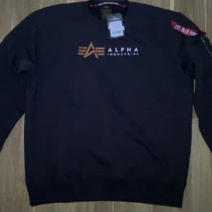 Alpha industries crewneck - Den är helt ny med lappen kvar, den är storleken XXL men den passar typ L skulle ja säga Den ser svart ut på första bilden men den är brun 