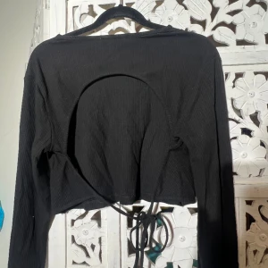 Långärmad tröja med öppen rygg  - Långärmad tröja med öppen rygg!  Tröjan är en lite kortare modell! Så den slutar strak över naveln.