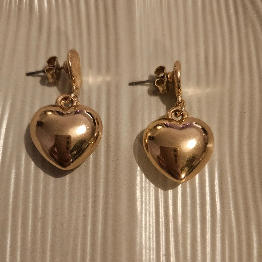 Ett par jättesöta, fina små guldfärgade hjärtan!   Örhängen väger lite så de är lätta att bära. Hjärtanen är tredimensionella, inte platta. Accessoarer.