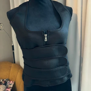 Korsett - Super snygg svart korsett som ger as najs pushup. Väldigt unik med ”straps” man kan fästa som man vill. 
