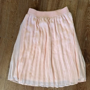 Rosa plisserad kjol från Lindex - Stl 134-140 sparsamt använd 