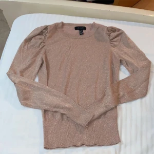 Glittrig rosa tröja - En ursnyygg glitter tröja i rosa. Passar till allt och den är sååå fiiinn. Har fått många komplimanger när jag har haft på mig den. Glittret är jättetydligt och gör så att tröja skiner🤩 är i storlek 34/XS. köparen står för frakten ❤️