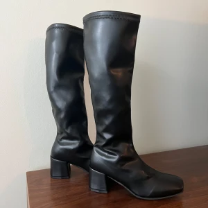 Knähöga stövlar i svart  - Jättefina knähöga stövlar i storlek 38. Helt oanvända (se undersidan av skon). Tyvärr lite för små för mig (använder 38-39). Finns även i off-white