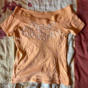Off-shoulder t-shirt - Orange off-shoulder t-shirt med vit detalj på framsidan. Står inget märke så skriver in Zara. Sitter som S-M✨nyskick